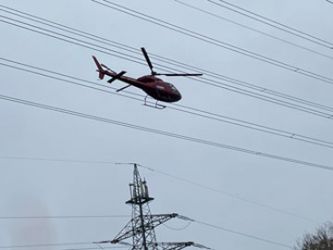 Hubschrauber nähert sich den 120-kV-Leitungen